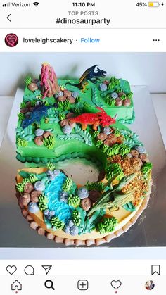 a cake that is shaped like the letter e with animals and plants on it, sitting on a table