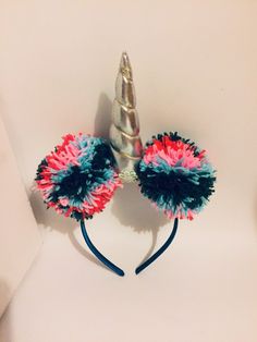 a pair of colorful hair accessories on top of a white surface with a unicorn's horn