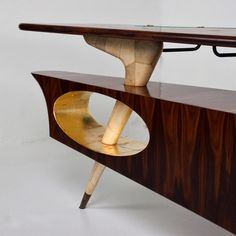 a wooden table with a glass top and two curved shelves on it's sides