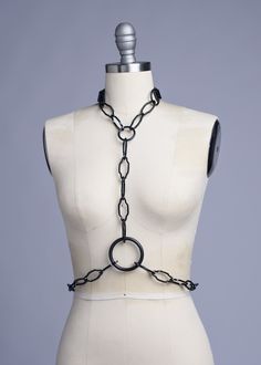 The Black Cathedral Chain Harness belt is a simple, elegant body chain harness created with geometric, Art Deco inspired black chain. All black hardware and black PVC straps. Buckles at back of neck and waist. All pieces are MADE TO ORDER, standard sizes XS-XXL. If your measurements fall outside these standards or you are unsure of what size to order, select "CUSTOM" and include your measurements in the notes upon checkout so we can adjust for a custom fit. Please contact us if you have any ques Elegant Black Party Harness, Black Metal Waist Chain For Party, Black Party Waist Chain With Chain Strap, Edgy Black Metal Chain Belt, Black Chain Belt For Night Out, Black Metal Waist Chain With Chain Strap, Black Body Chain With Chain Strap For Night Out, Black Chain Belt With Chain Strap For Evening, Adjustable Black Chain Belt