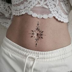 a woman's stomach with a tattoo design on her belly and the bottom part of her abdomen