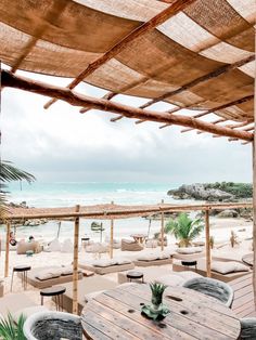 an outdoor dining area with tables and chairs on the beach