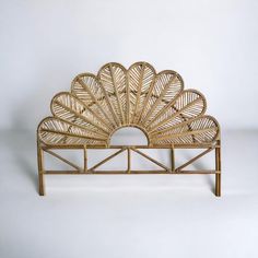 a wicker bed with a fan shaped headboard and foot board on it's sides