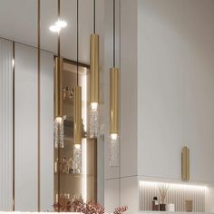 a kitchen with white cabinets and gold fixtures on the countertop, along with hanging lights