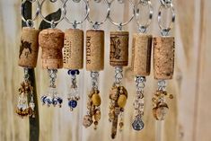 several wine corks are hanging from a metal rack with beads and charms attached to them