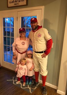 a man, woman and child dressed up in baseball uniforms