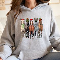 a woman sitting on a couch wearing a sweatshirt with horses printed on the front and sides