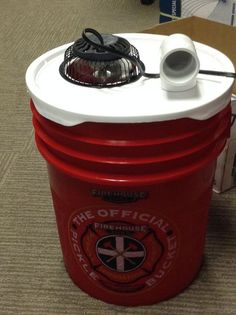 a red and white container sitting on top of a carpeted floor