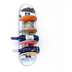 a skateboard mounted to the side of a wall with wine bottles on it's bottom shelf