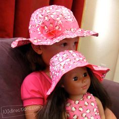 two dolls are sitting on a couch wearing hats