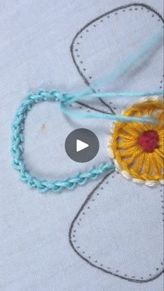 the video is showing how to make a crochet flower with yarn and thread