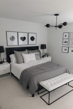 a white and gray bedroom with pictures on the wall