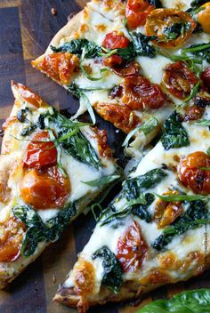 several slices of pizza with tomatoes, spinach and cheese