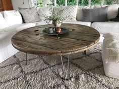 a living room with white couches and a wooden coffee table in the middle of it