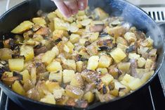 someone is frying potatoes in a skillet on the stove