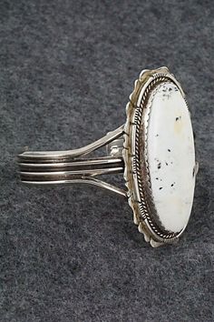 This vintage and stunning White Buffalo and sterling silver bracelet was made by a Navajo silversmith. The inside is signed L and stamped sterling.Size: 5 1/2" (will fit up to a 7" wrist)Gap: 1 1/2"Length: 2 3/8"Width: 1 1/4"Free shipping on all orders! We ship with USPS and always include tracking. All orders ship within a day of payment.Returns are accepted up to 30 days after you receive your order. Just send us a message. Our shop offers cash back or store credit. The item must be returned i White Sterling Silver Bracelet, Southwestern Style Oval Sterling Silver Cuff Bracelet, Southwestern Oval Sterling Silver Cuff Bracelet, Oval Southwestern Sterling Silver Cuff Bracelet, Oval Sterling Silver Cuff Bracelet In Southwestern Style, White Buffalo, Spring Sale, Sterling Silver Bracelet, Sterling Silver Bracelets