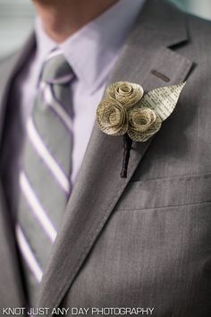 a man wearing a suit and tie with two flowers on it's lapel