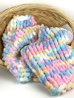 three crocheted mitts sitting in a wicker basket