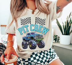 a woman wearing a t - shirt that says pit crew with a monster truck on it