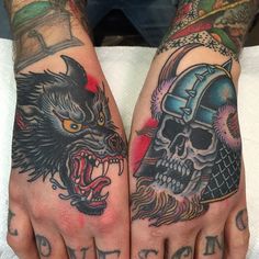 two hands with tattoos on them, one has a skull and the other has a helmet