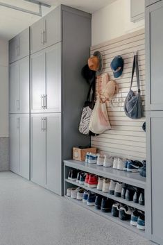 there are many pairs of shoes hanging on the wall in this shoe storage area with gray cabinets