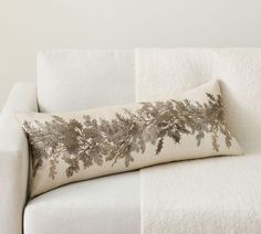 a white couch with a decorative pillow on it