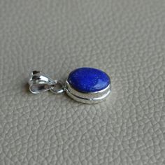 Gemstone-Lapis Lazuli Shape-Oval Stone Size- 10x14 MM Metal-925 Sterling Silver This One of a kind pendant is adorned with beautiful Deep Blue Lapis Lazuli gemstone set in sterling silver. Lapis Lazuli is the birthstone representing the zodiac sign of Taurus. About gemstones-Lapis Lazuli is a deep blue dazzling stone that shines light on the soul and helps us to awaken our divine purpose. It opens the door to a higher consciousness and allows you to keep feet on the ground and your head in the c Oval Cabochon Sterling Silver Gemstones, Blue Oval Sterling Silver Gemstones, Oval Lapis Lazuli Silver Jewelry, Oval Silver Lapis Lazuli Jewelry, Silver Jewelry With Oval Lapis Lazuli, Blue Oval Cabochon Gemstones For Gifts, Sapphire Jewelry With Oval Stone Setting, Oval Sapphire Jewelry With Stone Setting, Oval Sterling Silver Gemstones For Jewelry Making