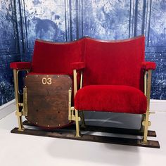 two red chairs sitting next to each other in front of a blue and white wall