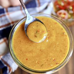 a spoon in a glass jar filled with peanut butter