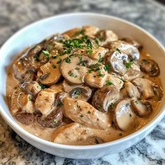 a white bowl filled with mushrooms covered in gravy