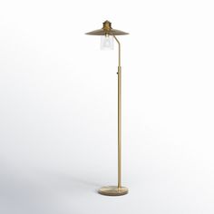 a brass floor lamp with a clear glass shade