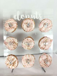 doughnuts are arranged in the shape of a circle on a clear acrylic sign