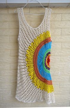 a crocheted tank top hanging on a brick wall