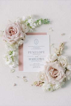 the wedding stationery is surrounded by pink and white flowers