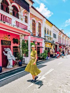 a woman is walking down the street in front of colorful buildings and people on skateboards