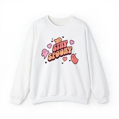 Embrace the Halloween season with our Stay Spooky Retro crewneck! This unique and adorable sweatshirt is perfect for anyone who loves all things spooky and cute. Crafted from high-quality fabric, it's comfortable for everyday wear or as part of your Halloween costume. The retro-style font adds a touch of nostalgia, while the cute ghosts and hearts give it a charming and playful twist. It's the ideal crewneck to show your love for Halloween in a sweet way. Ideal for any situation, a unisex heavy blend crewneck sweatshirt is pure comfort. With a loose fit, these crewnecks run true to size. These garments are made from 50% polyester and 50% cotton. This combination helps designs come out looking fresh and beautiful. The collar is ribbed knit, so it retains its shape even after washing. There Kawaii Letter Print Tops For Fall, Cute Crew Neck Sweatshirt With Funny Print, Cute Sweatshirt With Funny Print And Crew Neck, Kawaii Letter Print Sweatshirt For Fall, Trendy Crew Neck Sweatshirt With Character Print, Fall Kawaii Graphic Print Sweatshirt, Fall Kawaii Sweatshirt With Graphic Print, Cute Crew Neck Sweatshirt With Slogan, Cute Slogan Crew Neck Sweatshirt