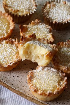 small desserts are sitting on a plate with some powdered sugar covering the top