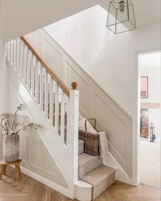 a white staircase with wooden handrails leading up to the second floor