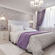 a bedroom with purple and white decor in the corner, along with a chandelier