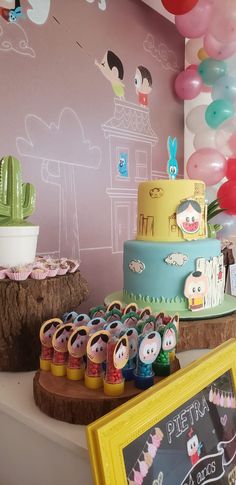 there is a cake on the table with balloons in the background and other decorations around it