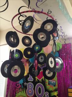 a bunch of records hanging from the ceiling in front of a party banner and streamers