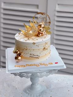 a white cake with gold decorations on top