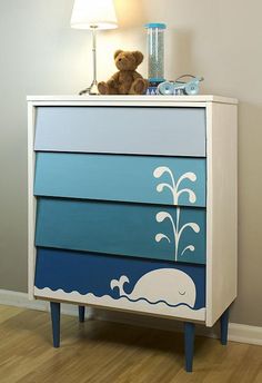 a blue and white dresser with an elephant painted on the side by it's legs