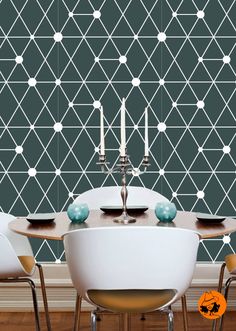 a dining room table with four chairs and a wallpaper design behind it that has geometric shapes