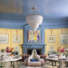 a dining room filled with lots of tables and chairs next to a fire place covered in pictures