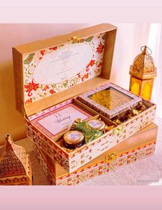 an open wooden box filled with assorted items on top of a white tablecloth