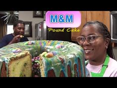 a woman standing in front of a cake with icing and candy on the top