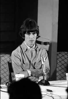 a man sitting at a table with microphones in front of him