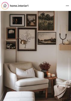 a living room with pictures on the wall and a chair next to a table in front of it