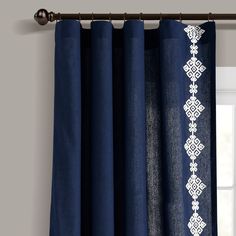 blue curtains with white lace on them hanging from a curtain rod in front of a window